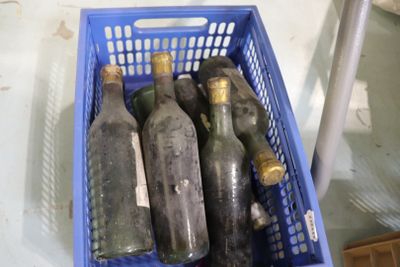 six bouteilles de vin dans un panier bleu posé sur une table