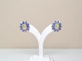 une paire de boucles d'oreilles en oplite et saphir bleu, présentées sur un socle blanc