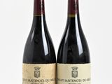 two bottles of wine sitting next to each other on a white surface
