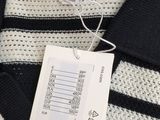 black and white striped sweater with a tag on it