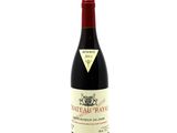 the bottle of wine is sitting on a white surface