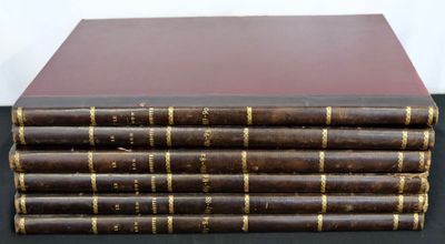 six old books stacked on top of each other on a table