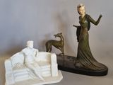 une statue représentant une femme et un chien posée sur une table