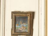 many pictures on the wall above the toilet in the bathroom