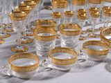many glasses and cups on a table with gold rims