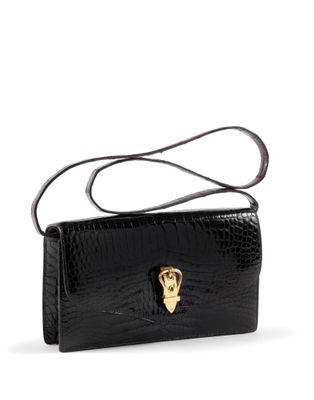 a black crocodile skin purse with a gold skull on the front