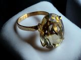 a gold ring with a faceted yellow topaz stone on it