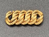 a close up of a gold bracelet on a gray surface