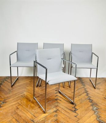 trois chaises dans une pièce avec un parquet et un mur blanc