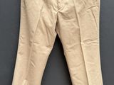 un pantalon beige suspendu à un cintre accroché au mur