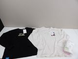 two t - shirts that are on a table next to a bottle of water