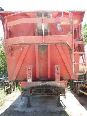 une photo d'un camion-benne rouge garé sur le bord de la route
