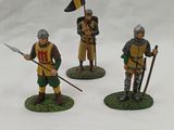 three figurines of knights with spears and flags on a white surface