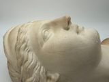 sculpture of a woman ' s head resting on a white surface