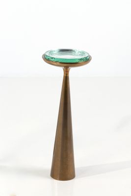 a small green glass plate on a gold pedestal