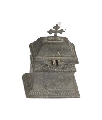 une petite boîte en métal surmontée d'une croix