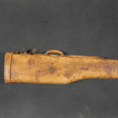 an old wooden gun case with a leather handle on a black surface