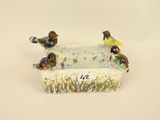 three birds sitting on a planter on a white surface