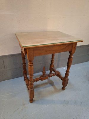 a small wooden table with a glass top on the floor
