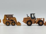 five toy construction vehicles that are lined up on a white surface
