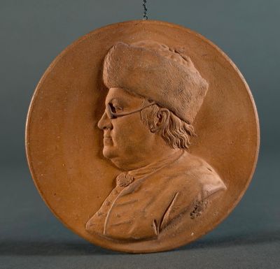 a brown medallion with a picture of a man on it