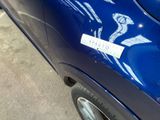 a blue car with a sticker on the side of it