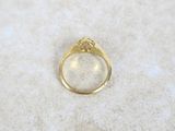 a close up of a gold ring on a white surface