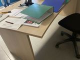 a desk with a lot of papers on it and a chair in front of it