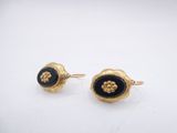 a pair of gold and black enamel flower earrings