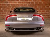 a silver sports car parked in front of a brick wall