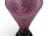 a purple glass vase with a black base on a white surface