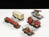 quatre petits trains miniatures posés sur une surface blanche
