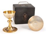 an antique brass goblet and a box on a white background