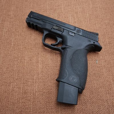 a picture of a black gun on a brown surface