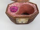 a wicker basket with a pink ball inside of it
