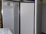 two open refrigerators sitting in the corner of a room