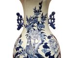 a blue and white vase with a peacock on it