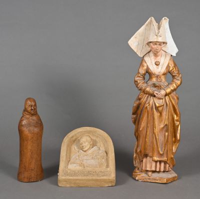 three carved figurines of a woman and a statue of a man
