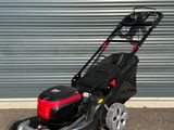 l'image d'une tondeuse à gazon garée devant une porte de garage