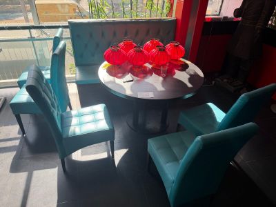 brightly colored chairs and a table in a room with a balcony