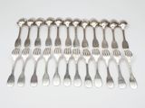 six fourchettes et six cuillères alignées sur une surface blanche