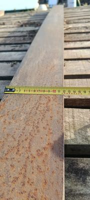un mètre ruban posé sur un morceau de bois, sur un toit