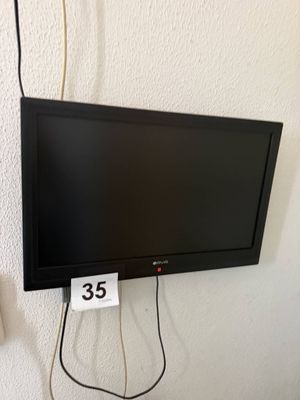 une télévision à écran plat accrochée au mur à côté d'un chargeur