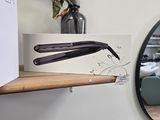 a picture of a hair dryer on a shelf next to a mirror