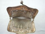 someone is holding a silver purse with a chain around it