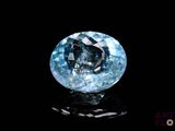a close up of a blue diamond on a black surface