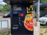 un distributeur automatique sur lequel est posée une pizza