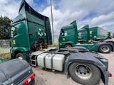 several green semi trucks parked in a parking lot next to each other