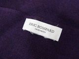 the label of a purple sweater with a white tag on it