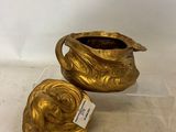 two gold vases sitting next to each other on a table